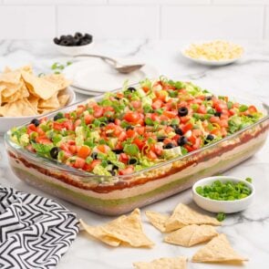 7 layer dip with a couple tortillas scattered around.