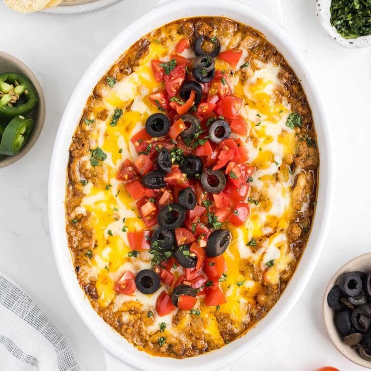 cheesy taco dip in a white baking pan.