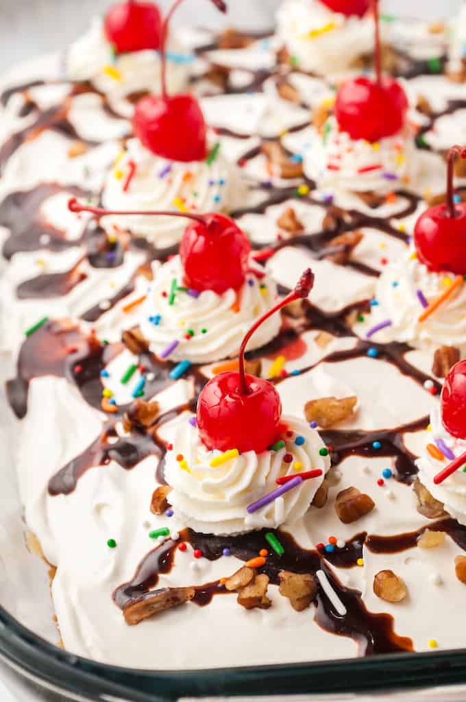 Banana Split Cake close up with whipped cream and cherries