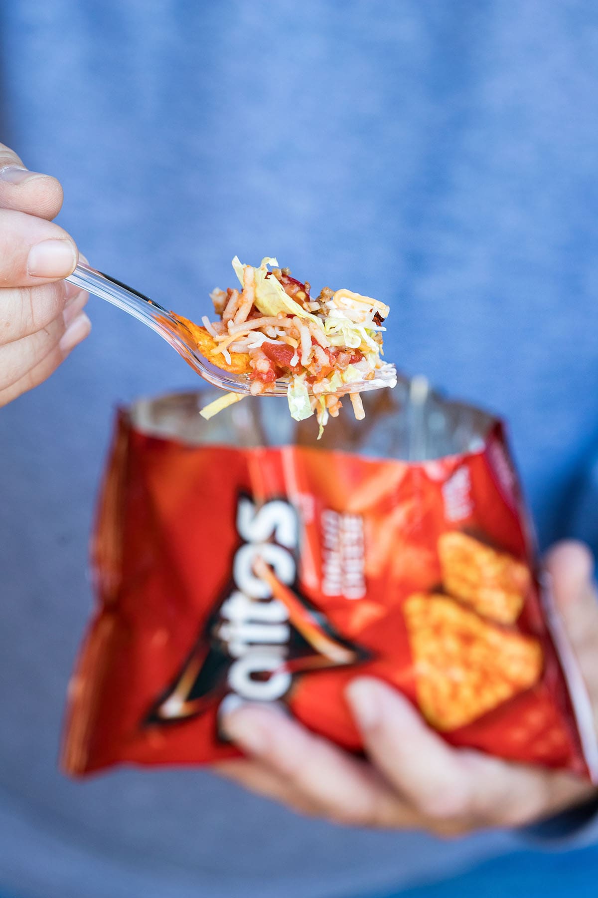 A hand holding a forkful of taco ingredients.