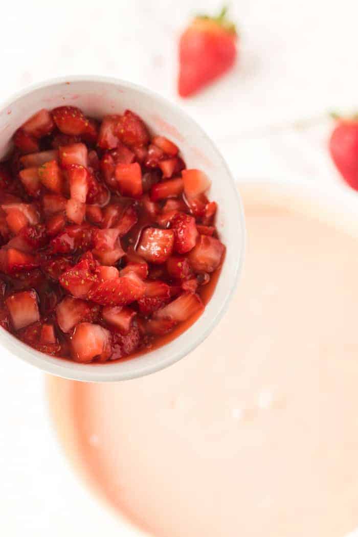 Fresh strawberries pouring into cake batter