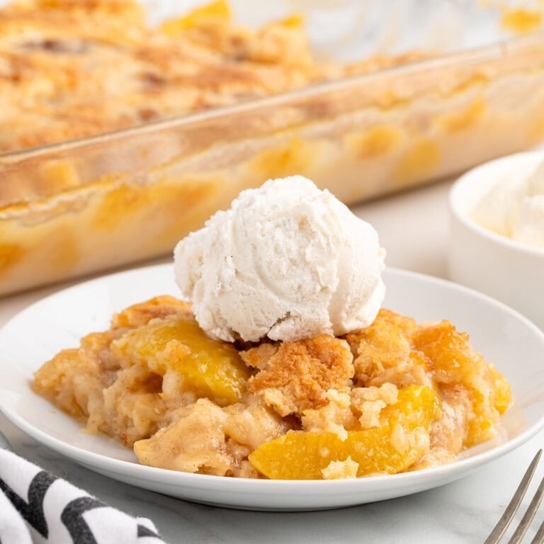 peach dump cake topped with a scoop of ice cream.