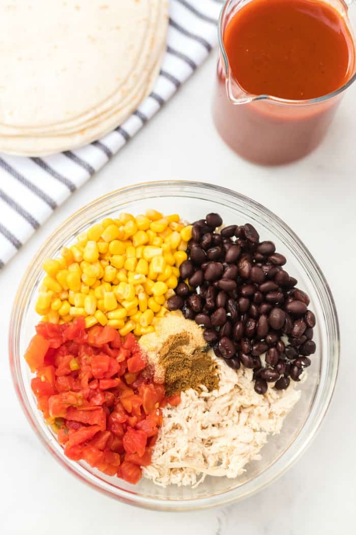 tomatoes, corn, beans and chicken in a glass bowl