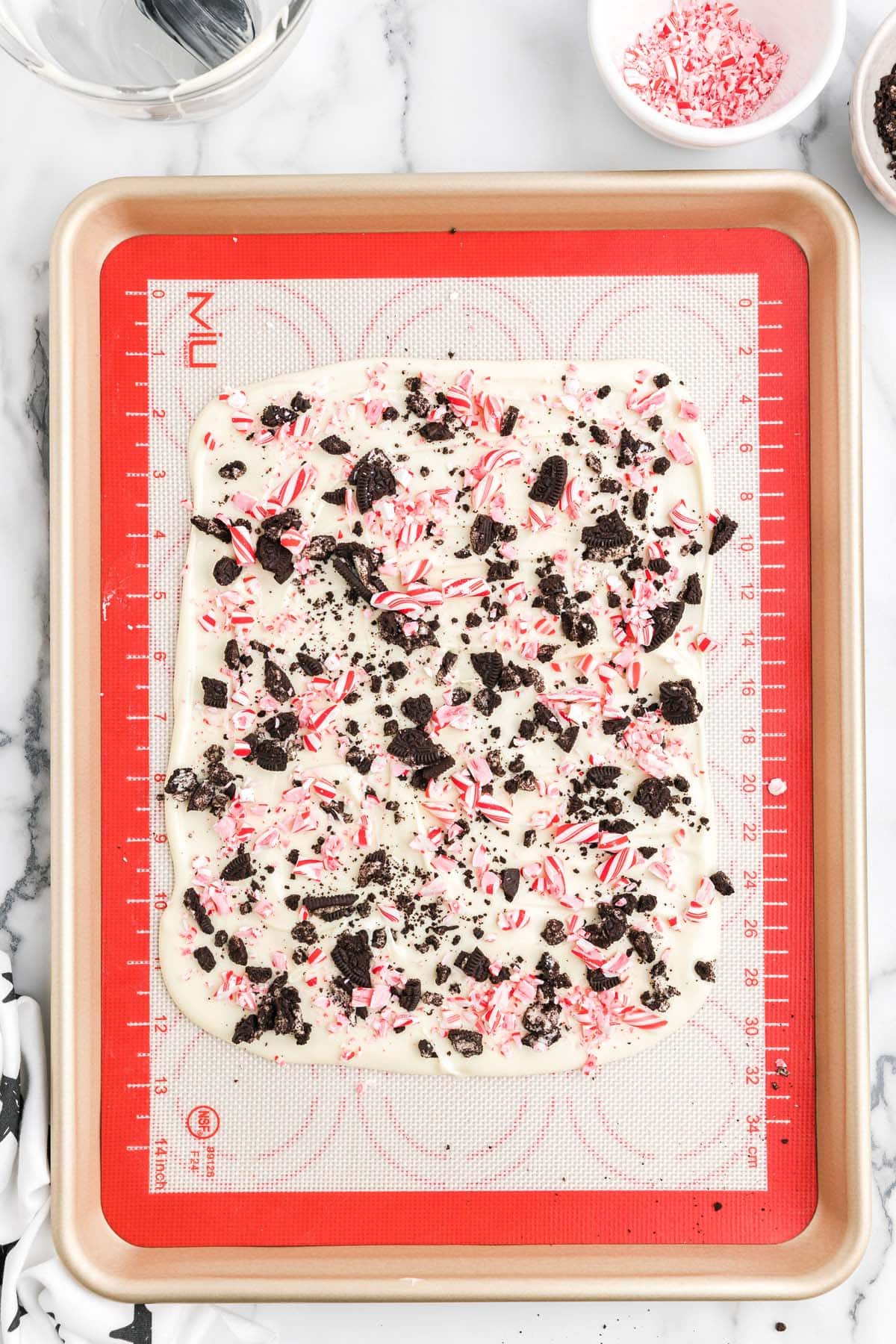 Sprinkle crushed peppermint and Oreos on the chocolate