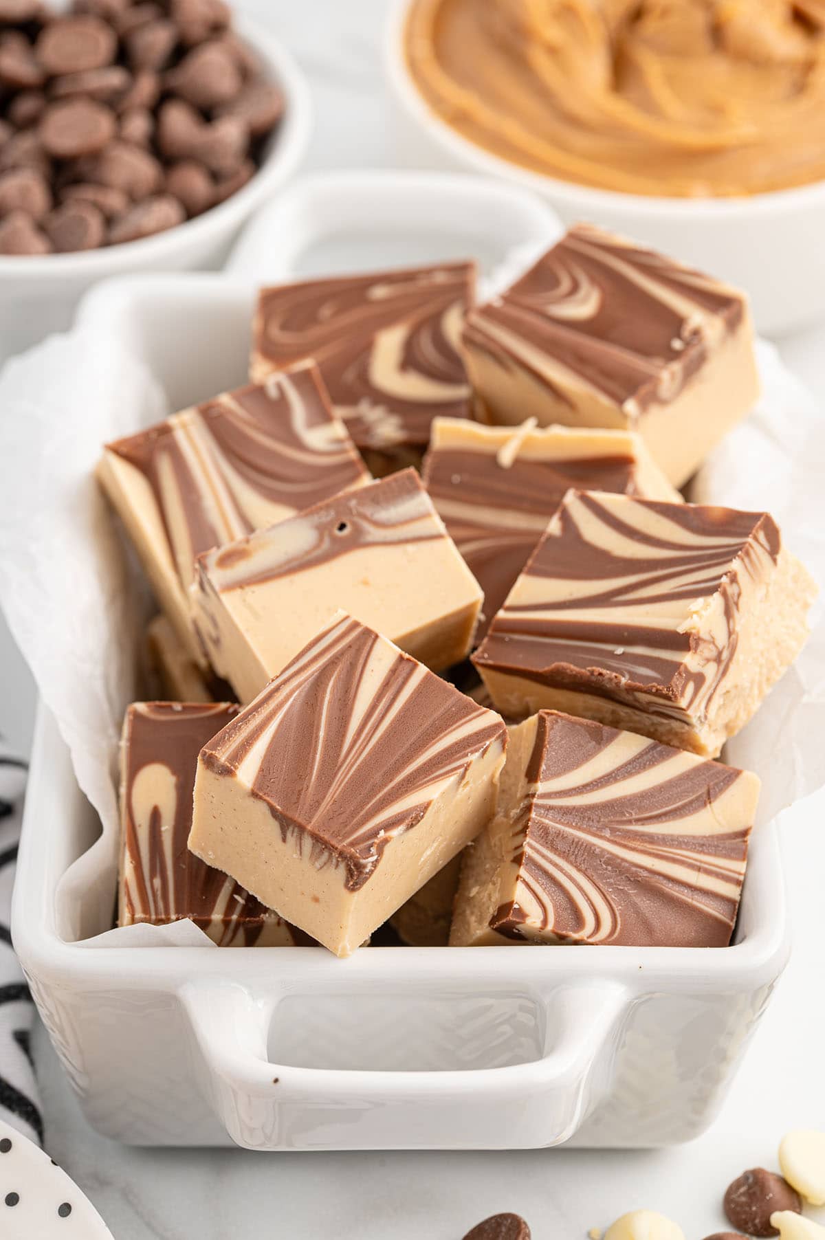 a couple of tiger butter fudge in a white dish.