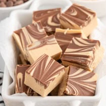 a couple tiger butter fudge in a white small casserole dish.