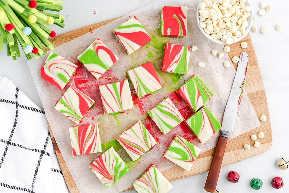 Christmas Fudge squares with red, green, and white swirls arranged on parchment paper.