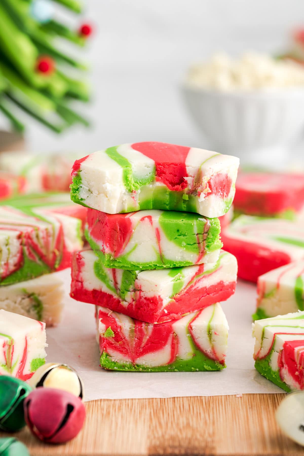 Stack of Christmas Fudge squares with red, green, and white swirls, one with a bite taken out.