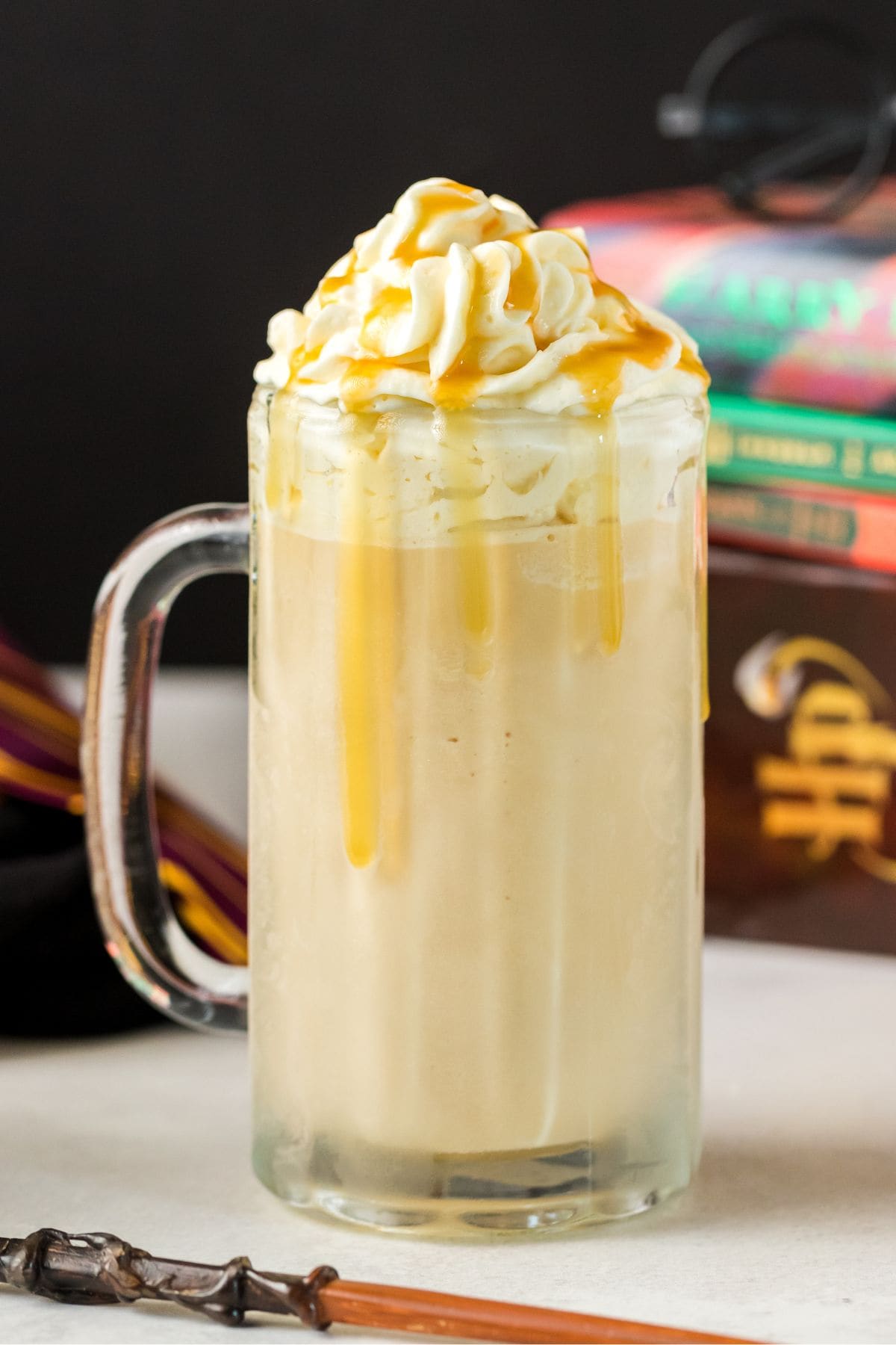 a glass of butterbeer with wizard wand on the table. 