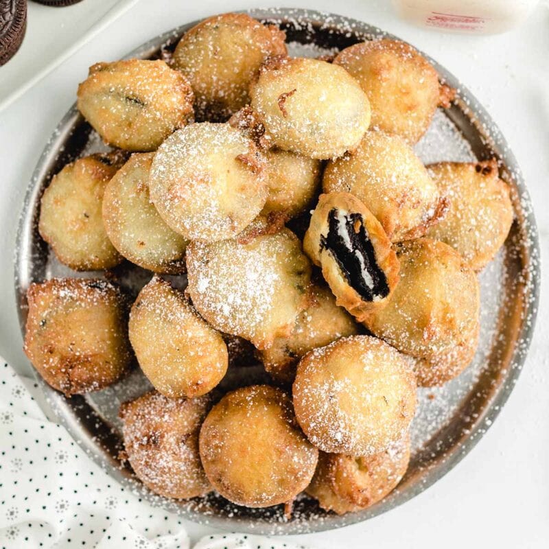 deep fried oreos stacked on a big plate.