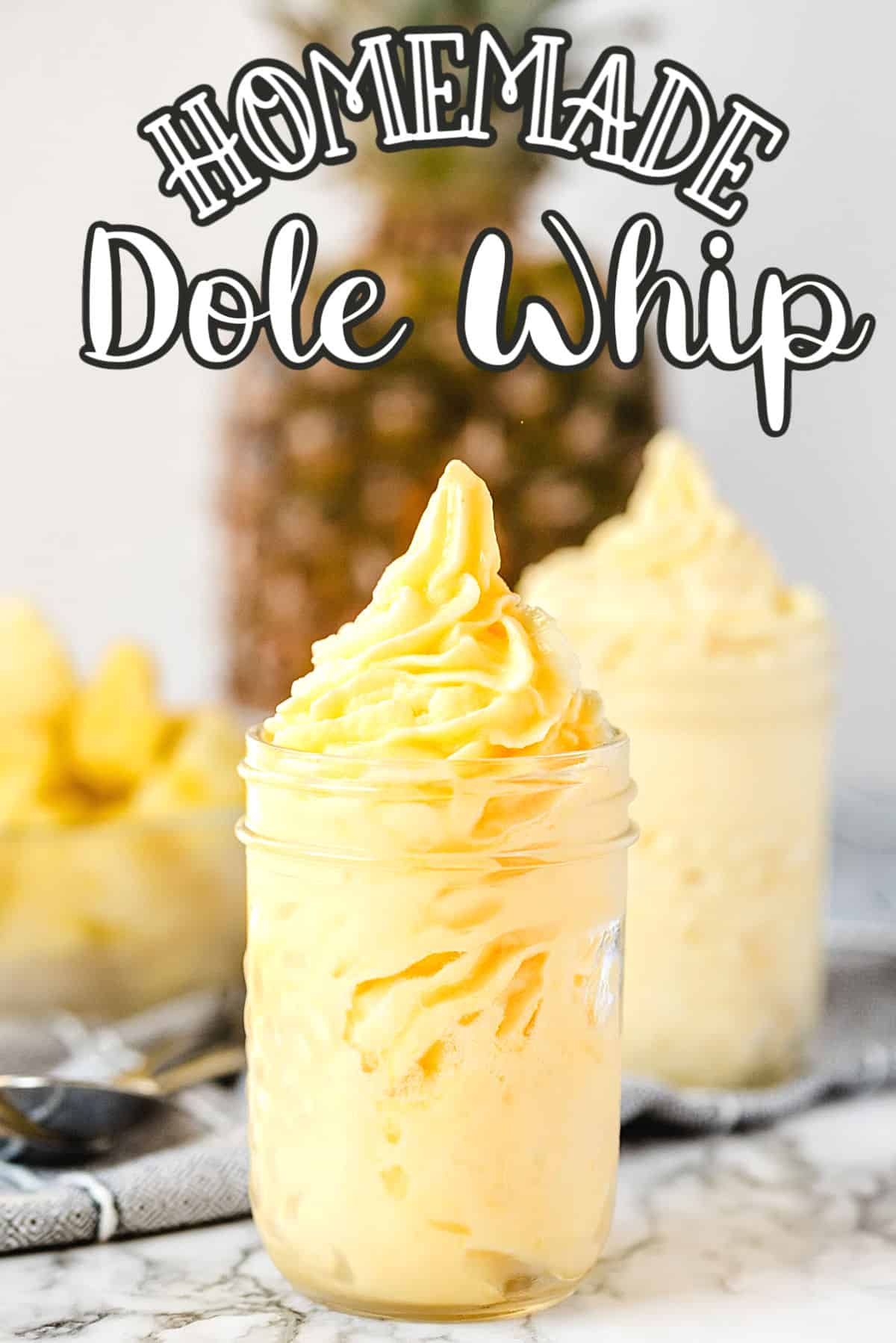 Homemade Dole Whip in a glass with a pineapple behind it