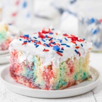piece of red white and blue jello poke cake on a white plate square