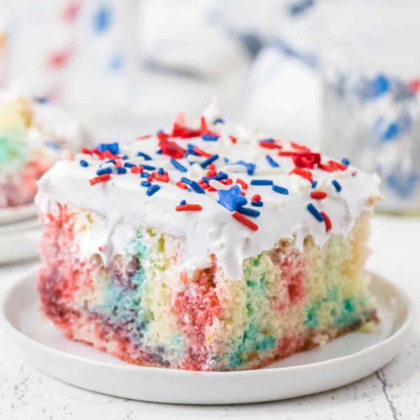 piece of red white and blue jello poke cake on a white plate square