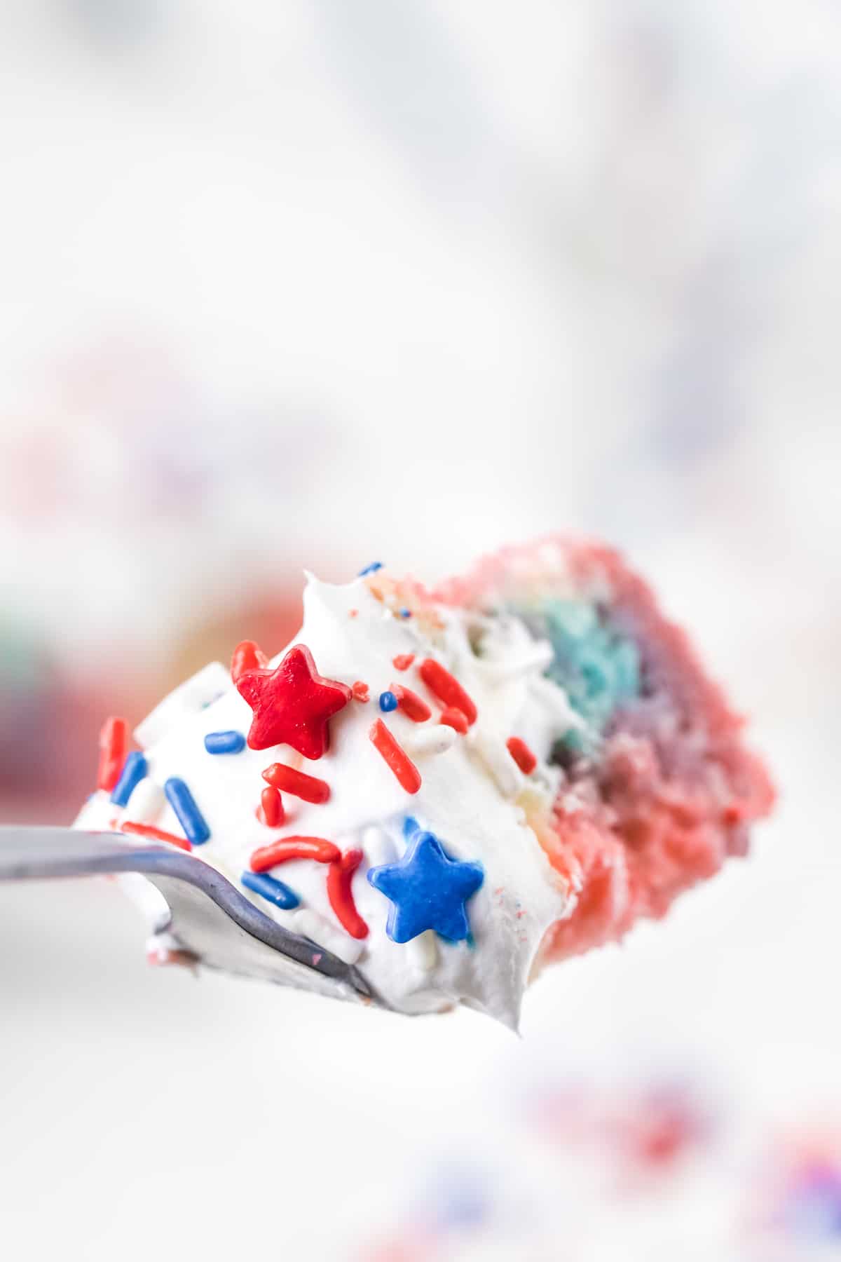 Bite of red white and blue poke cake on a fork
