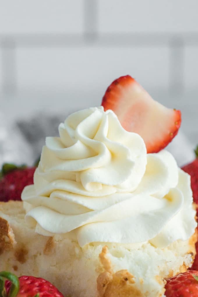homemade cool whip on top of a cake with a strawberry