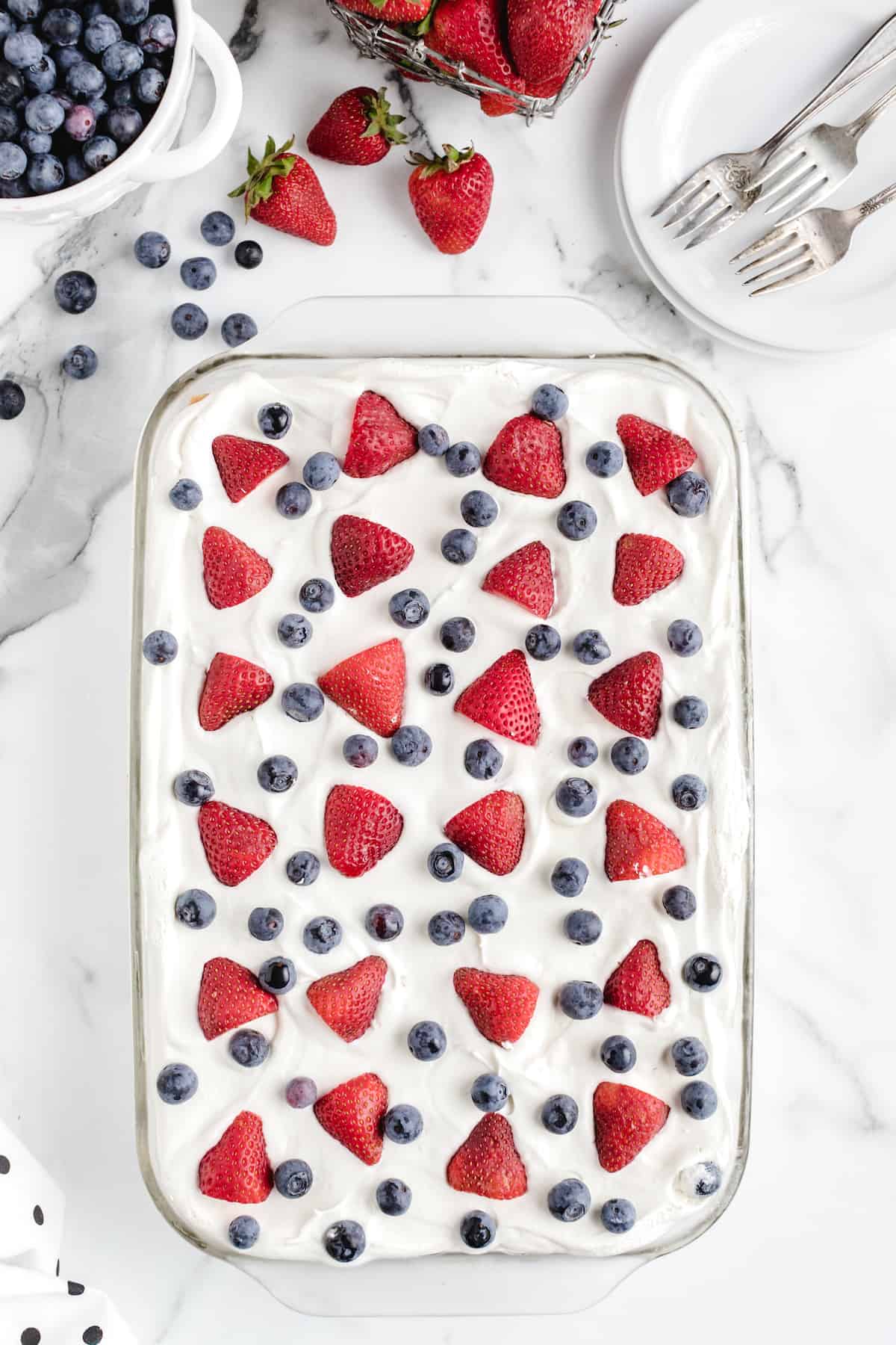 Berry Icebox Cake in a baking dish with strawberries and blueberries