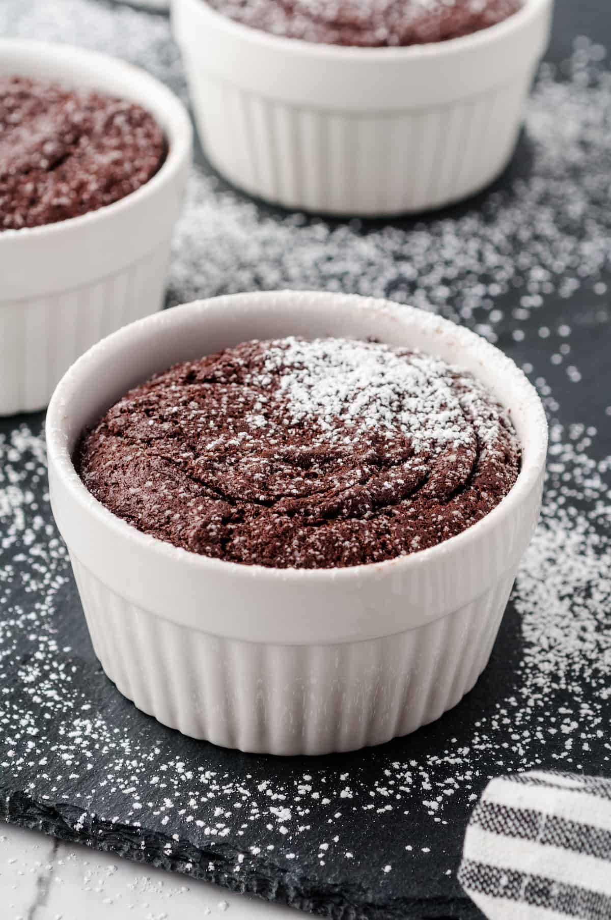 Chocolate Melting Cake in a white ramekin with powdered sugar on top