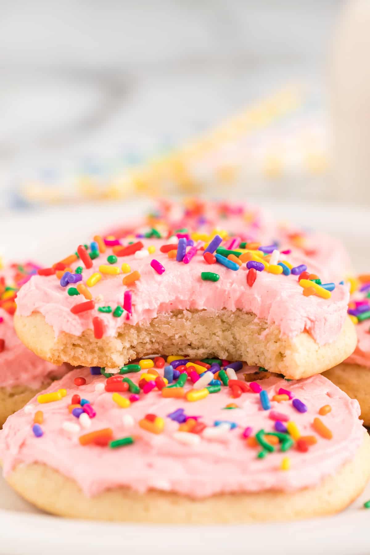 cookie with a bite out of it with pink frosting and sprinkles