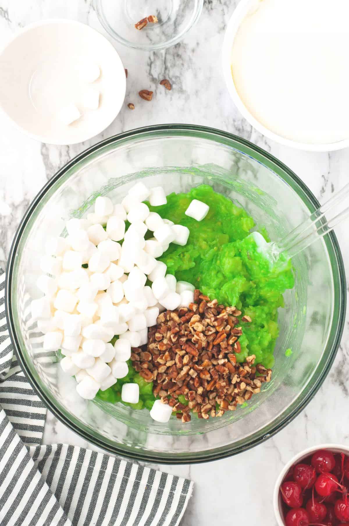 Marshmallows, pudding, pecans in a glass bowl