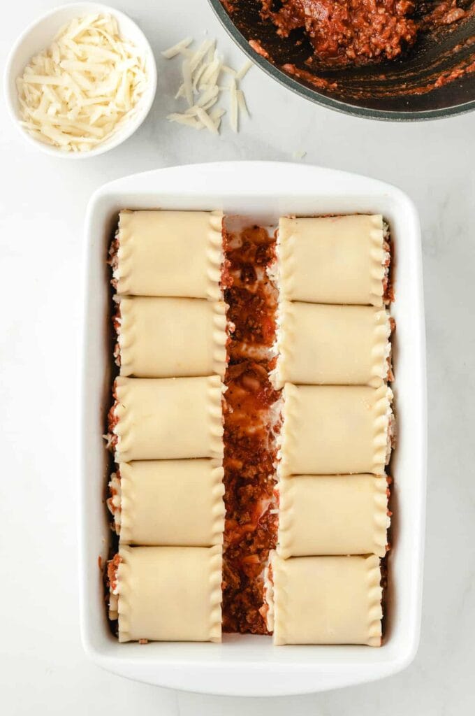 rolled up lasagna noodles in a casserole dish