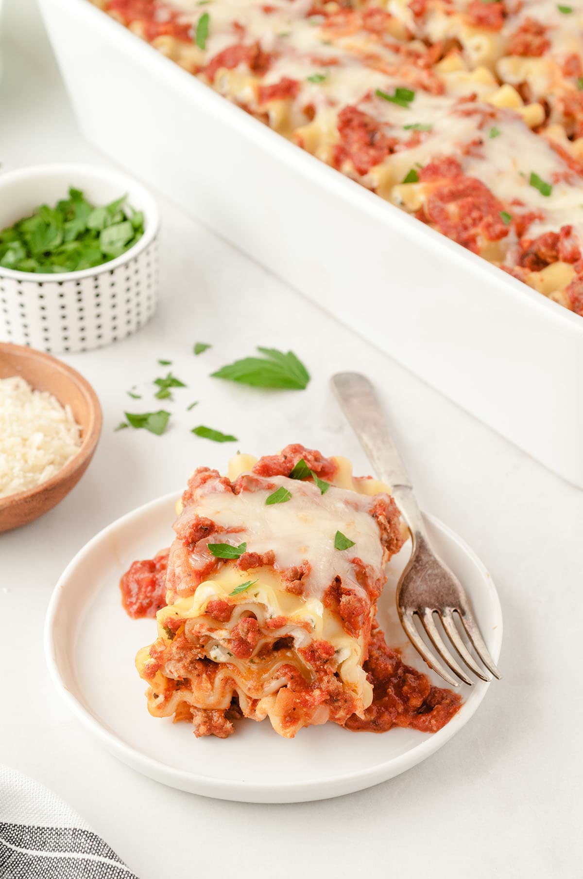 a plated slice of lasagna roll-ups with a fork beside it.