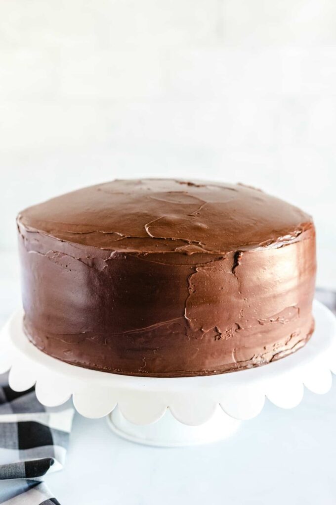 chocolate cake on a white cake plate