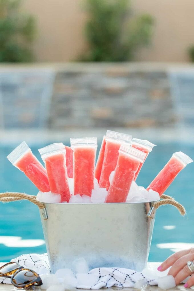 pink popsicles in a tub in front of a pool
