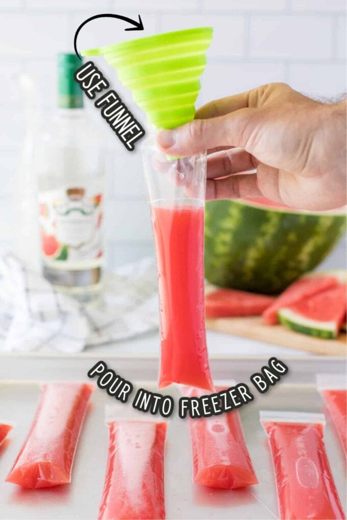 a funnel pouring watermelon vodka in a freezer bag