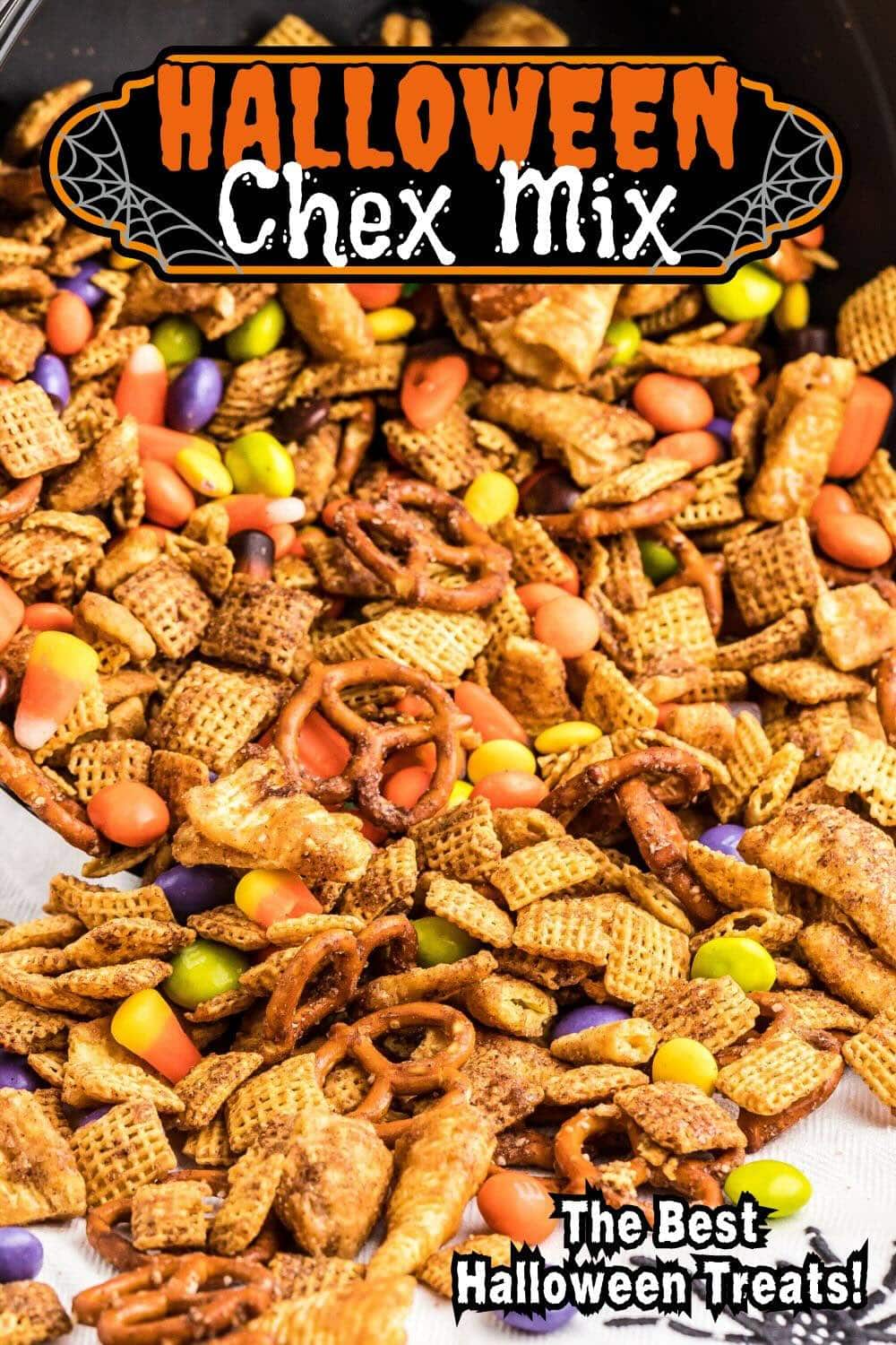 Close-up of Halloween Chex mix spilling from a cauldron.