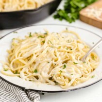 Fettuccine Alfredo on a white plate with a fork
