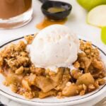 apple crisp served with ice cream on a plate.