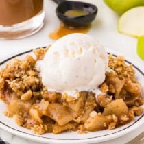 apple crisp served with ice cream on a plate.