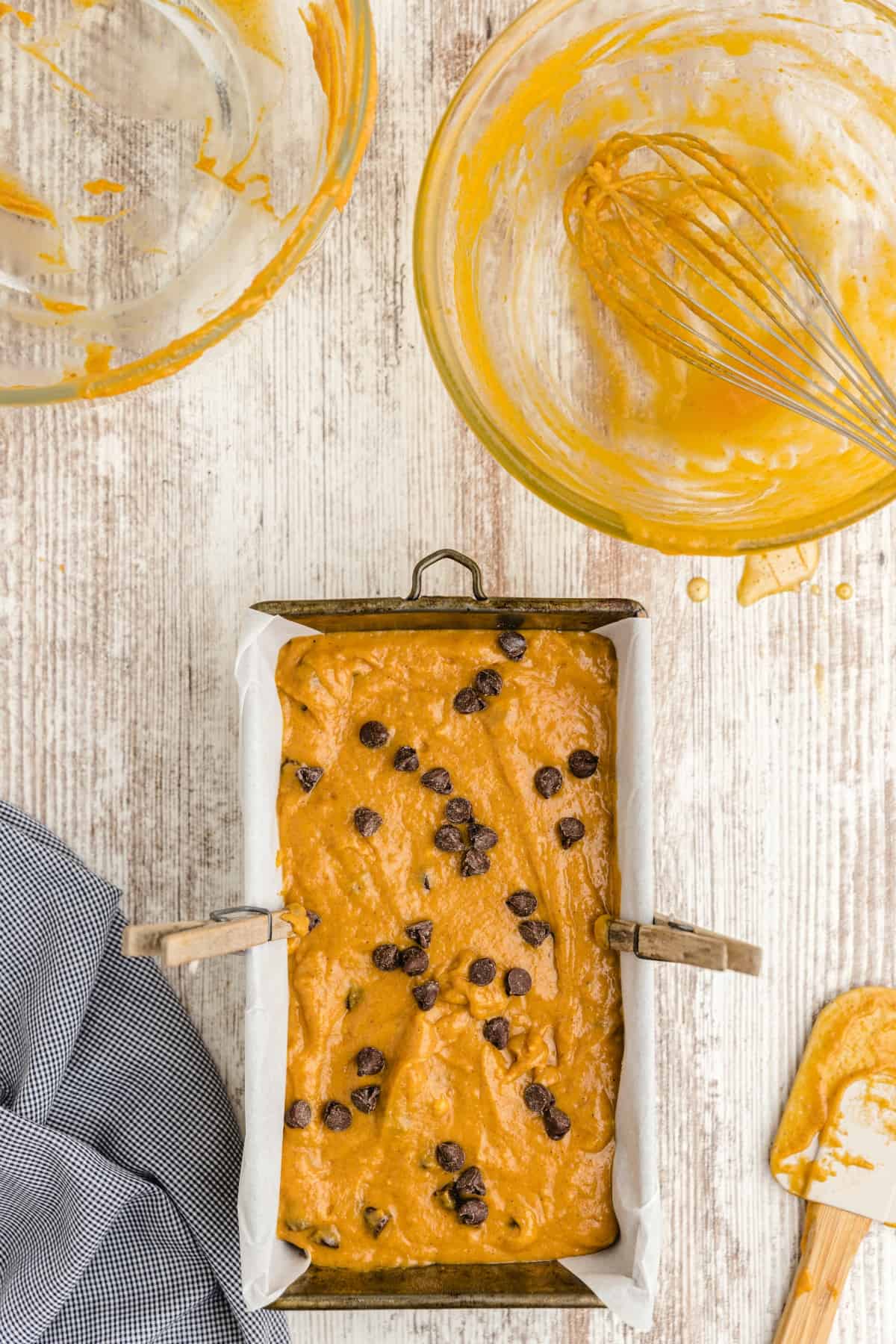 pumpkin bread batter in a loaf pan with chocolate chips on top