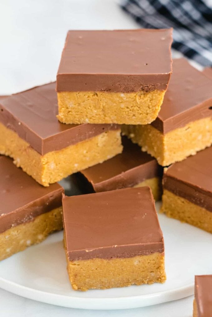 peanut butter chocolate squares stacked on a white dish