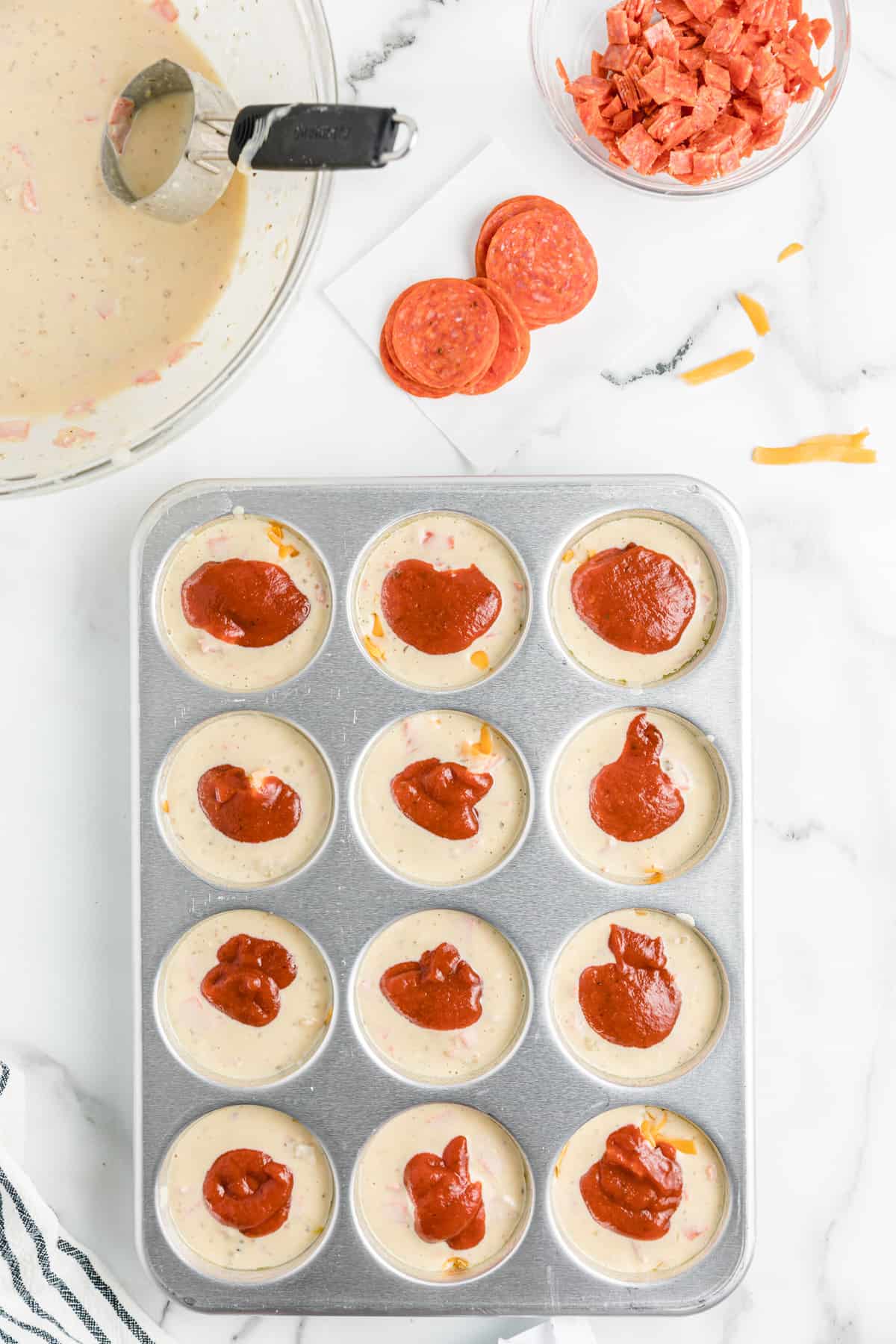 pizza sauce added to muffin cup