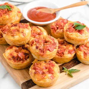 Pizza muffins stacked on a cutting board
