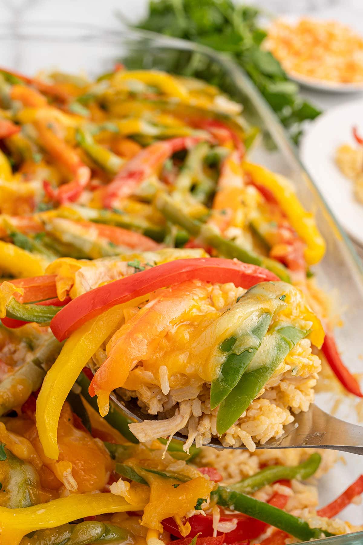 Spoonful of chicken fajita casserole with rice, peppers, and melted cheese.