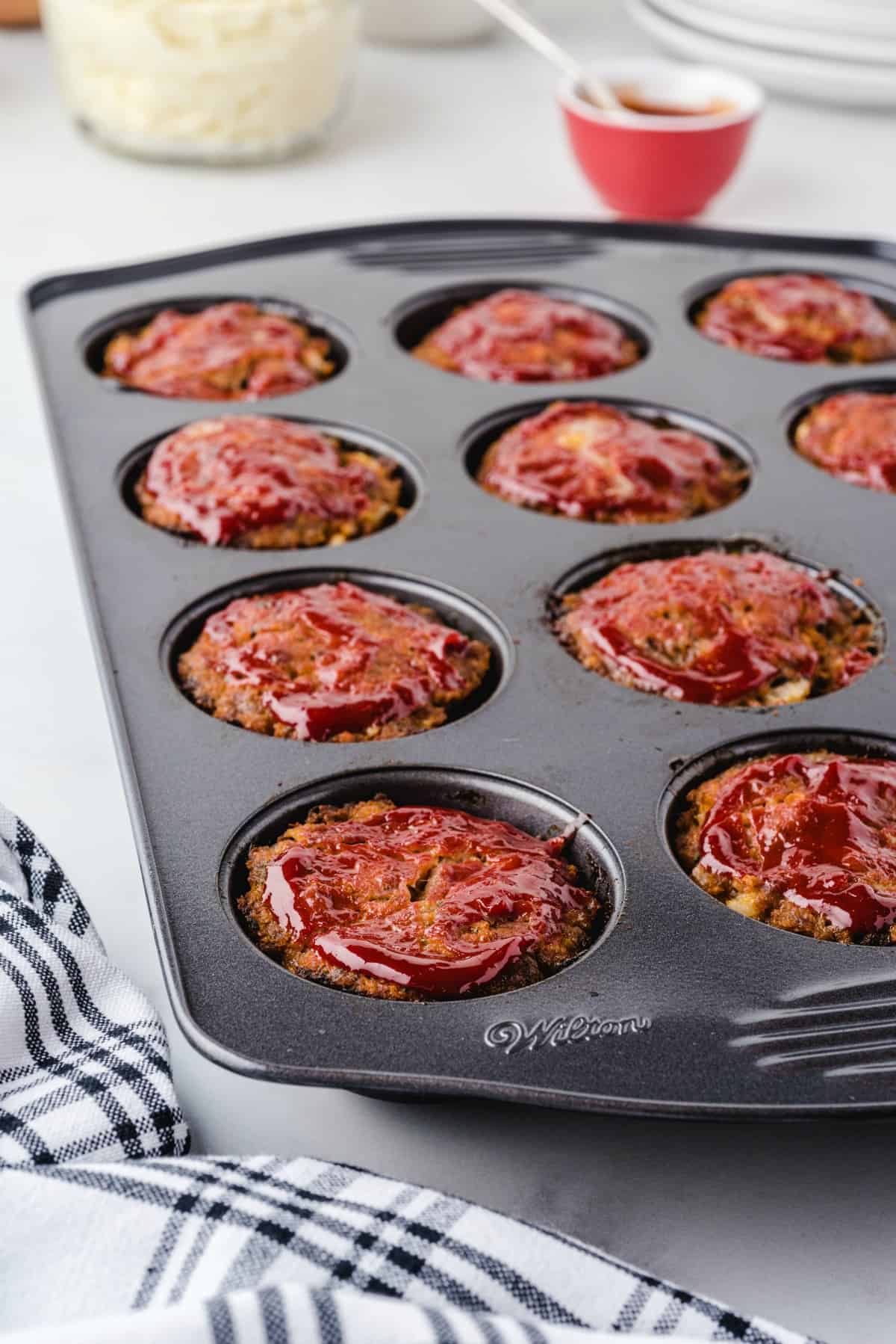 muffin pan meatloaf on top of white table. 