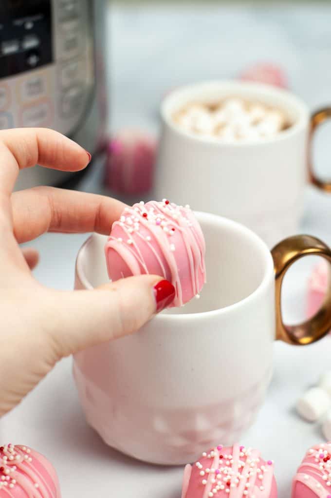 Pink Hot Chocolate Bombs being place in a mug