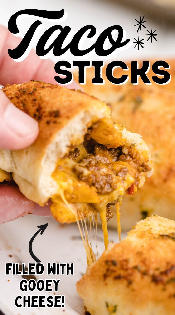 A hand grabbing a piece of taco stick with melted cheese coming out of it.