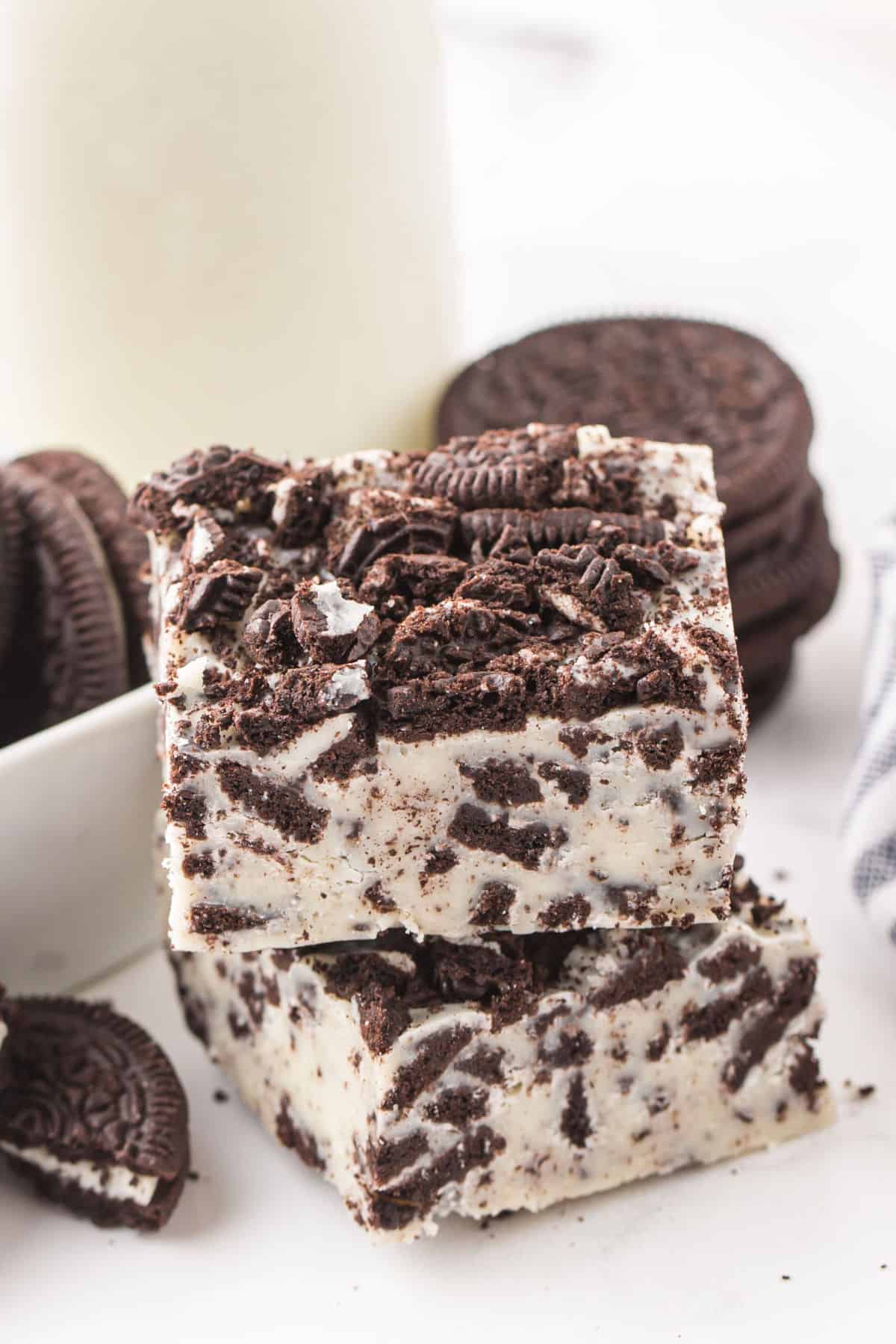 2 squares of Oreo Fudge stacked on top of white table. 