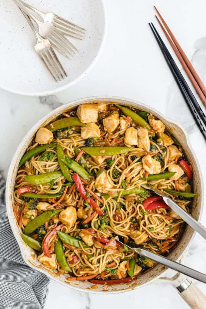 Chicken Lo Mein mixed in a pan with tongs