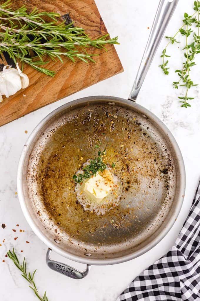 butter, cloves of minced garlic, red pepper flakes, the fresh rosemary and oregano in a skillet