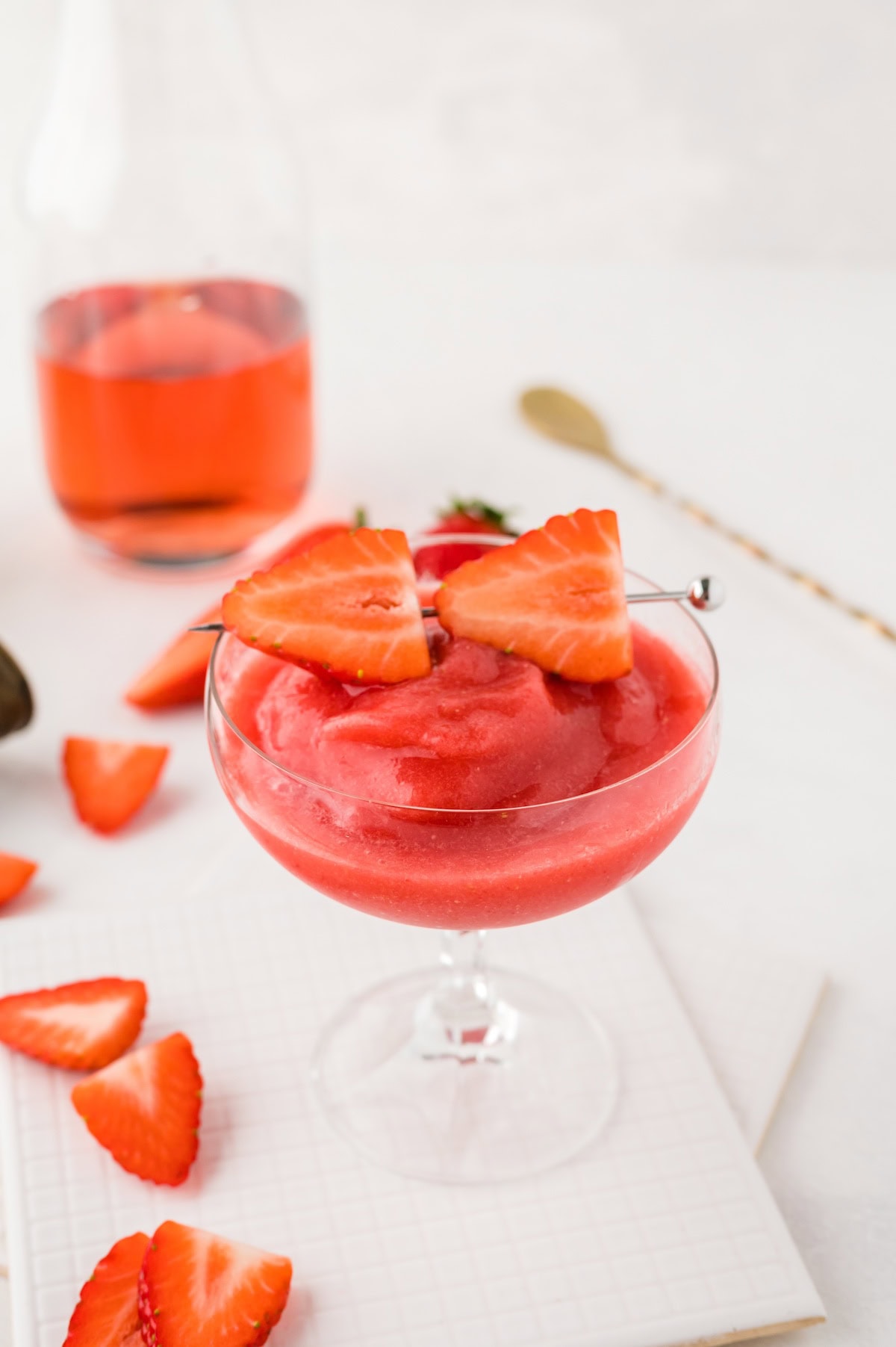 frose garnished with a stick with 2 slices of strawberries.