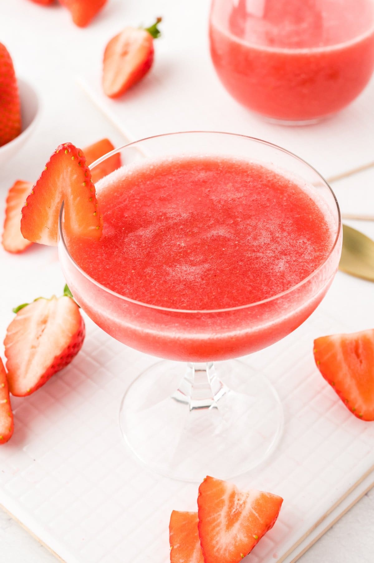 strawberry frose with a slice of strawberry on the glass rim.