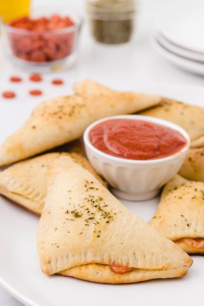 pizza pockets in a plate with sauce in the middle