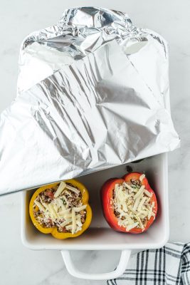 stuffed peppers in a pan covered in foil