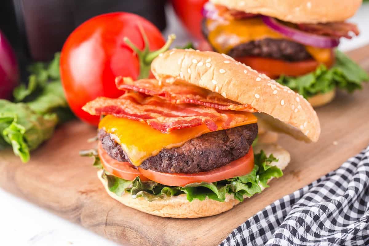 Juicy air fryer hamburger with lettuce, tomato, onion and a sesame bun.