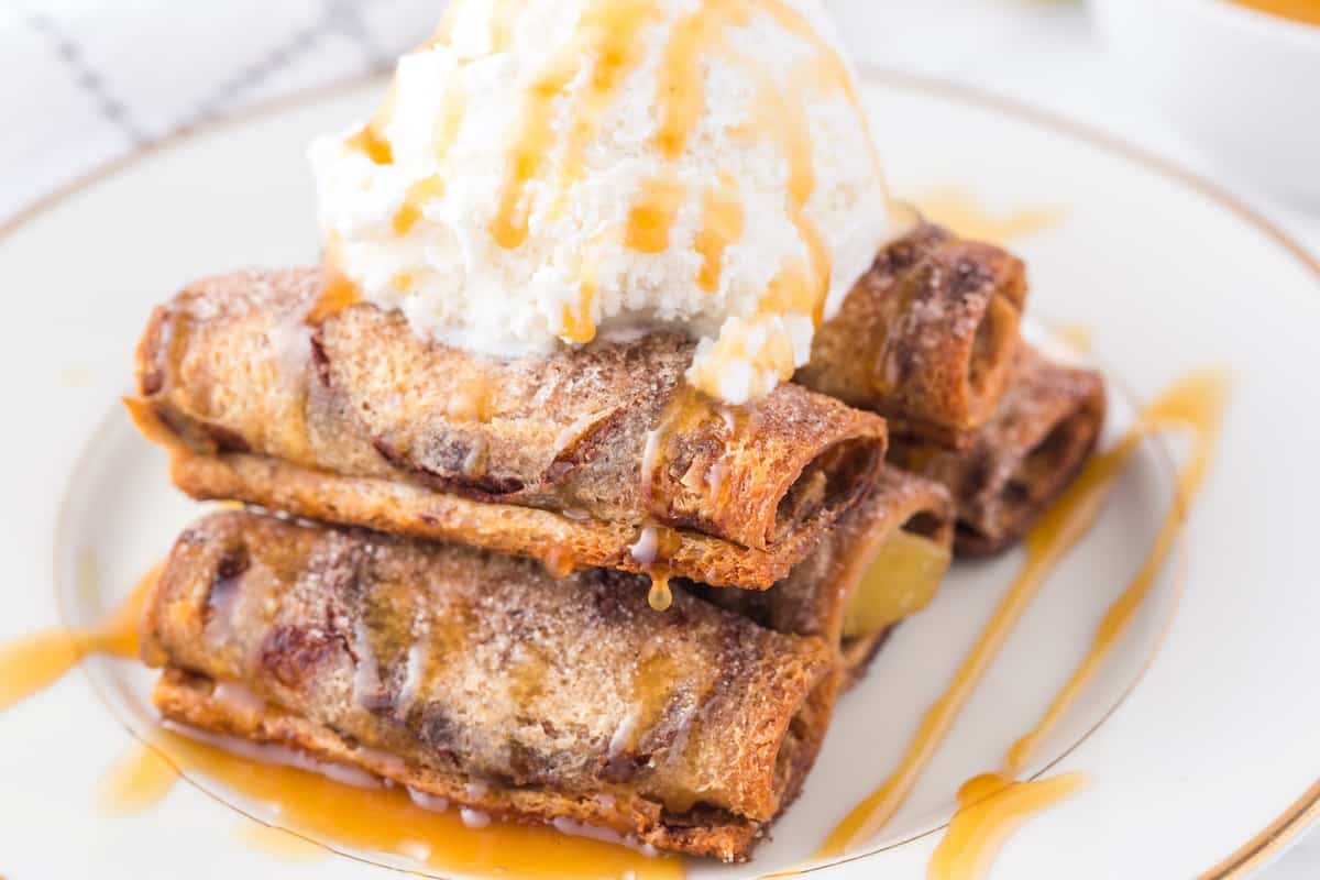 apple pie roll up on a plate with a scoop of ice cream