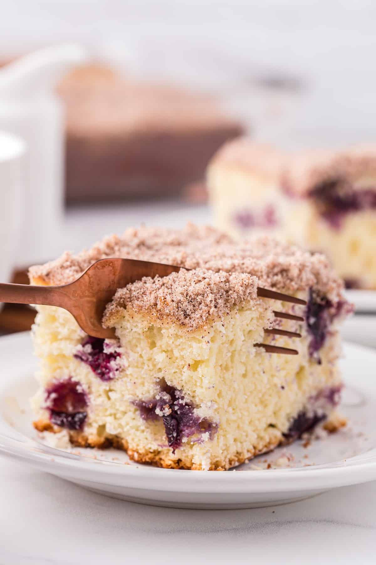 blueberry breakfast cake being cut with fork.